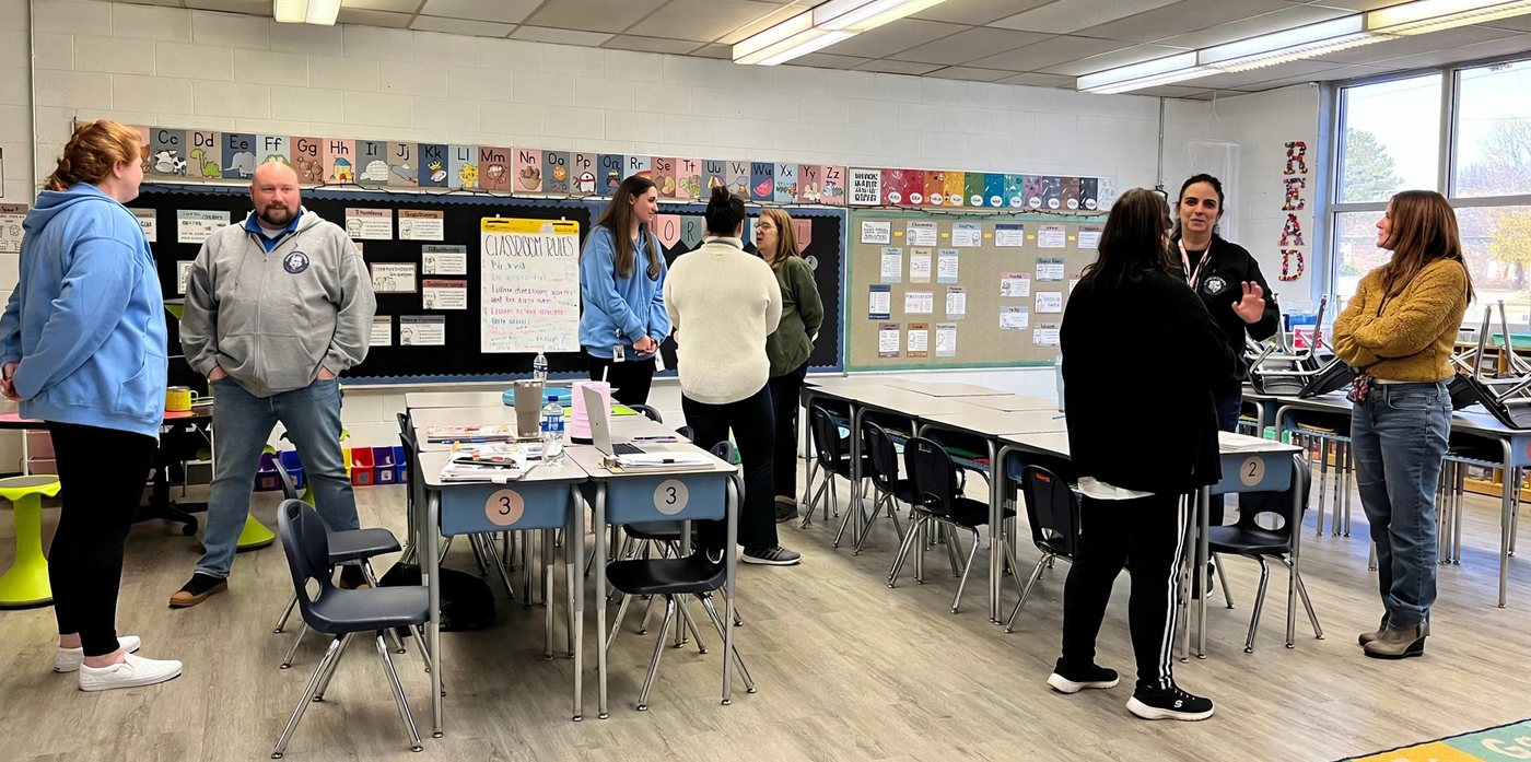 Dina Secchiaroli talking with a group of teachers in an elementary classroom during a professional learning session